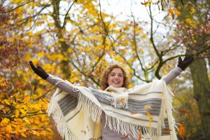 Beautiful older woman with arms spread outdoors