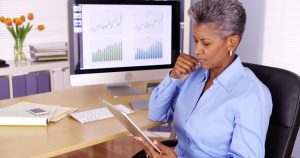 Senior african manager working at desk with tablet