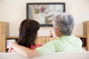 Couple watching television using remote control