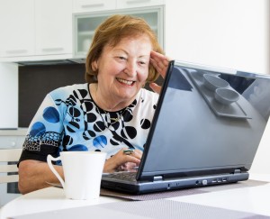 Elder woman at the computer searching the internet